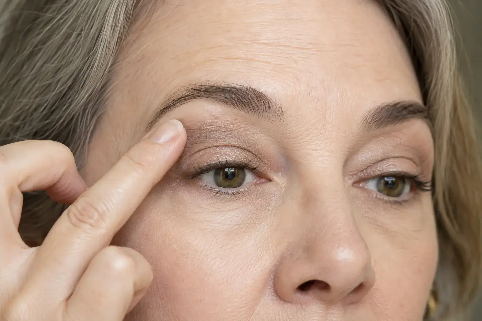 Mature hooded eye with cream shadow blended just above the natural crease