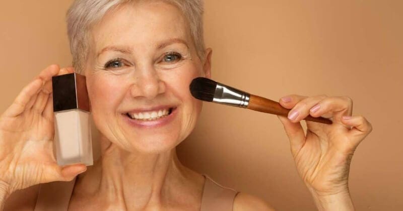 mature woman applying foundation