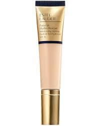 Estée Lauder Futurist Hydra Rescue Foundation in a soft gold and navy tube, placed next to a makeup brush.