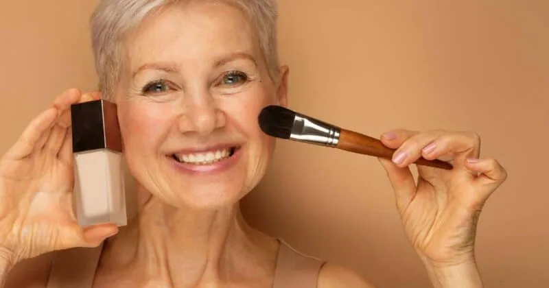 mature woman applying foundation