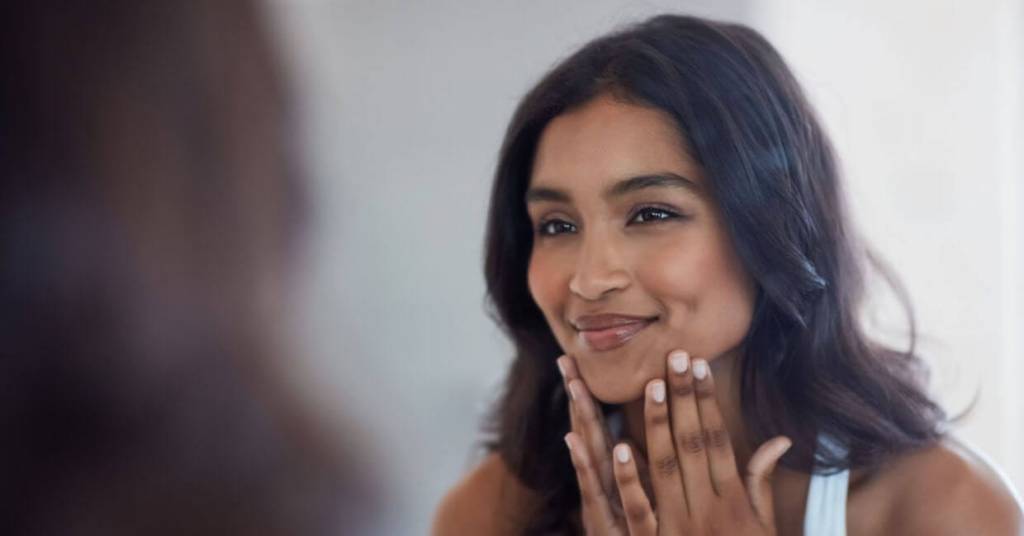 Confident mature woman smiling with minimal makeup, showcasing embrace your unique beauty for ageless confidence over 50.