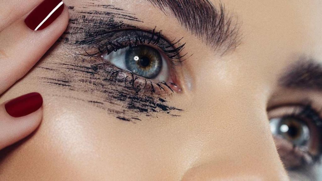 Mascara wand coating lashes for volume, showing invest in volumising smudge-proof mascara for fuller lashes on aging eyes.
