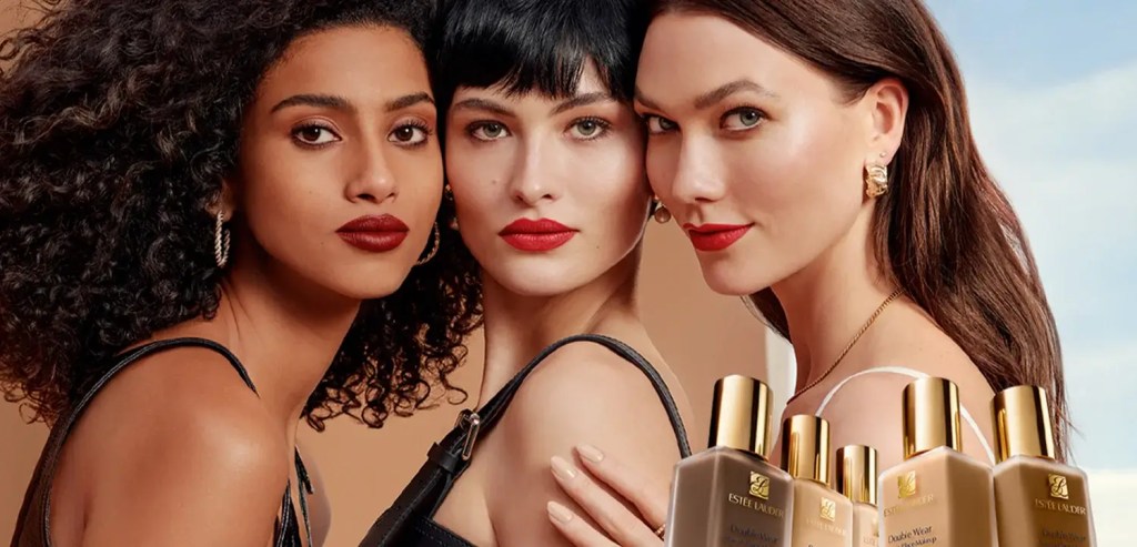 Three women with different skin tones wearing full-coverage foundation and red lipstick, showcasing a smooth, even complexion.
