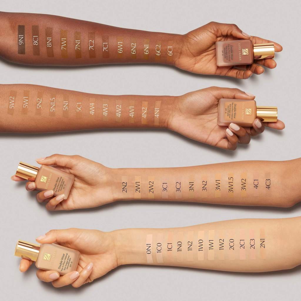 Estée Lauder Double Wear foundation shade swatches on arms, displaying a wide range of tones and undertones.